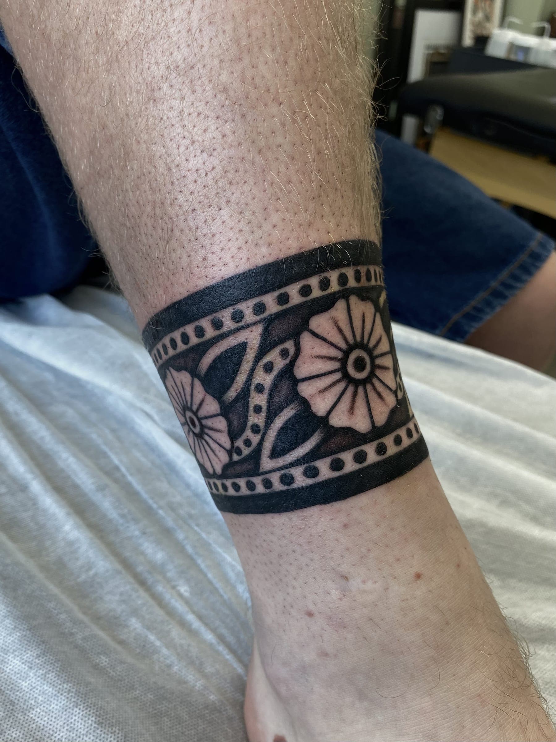 Black traditional flower band tattoo with dotwork edges