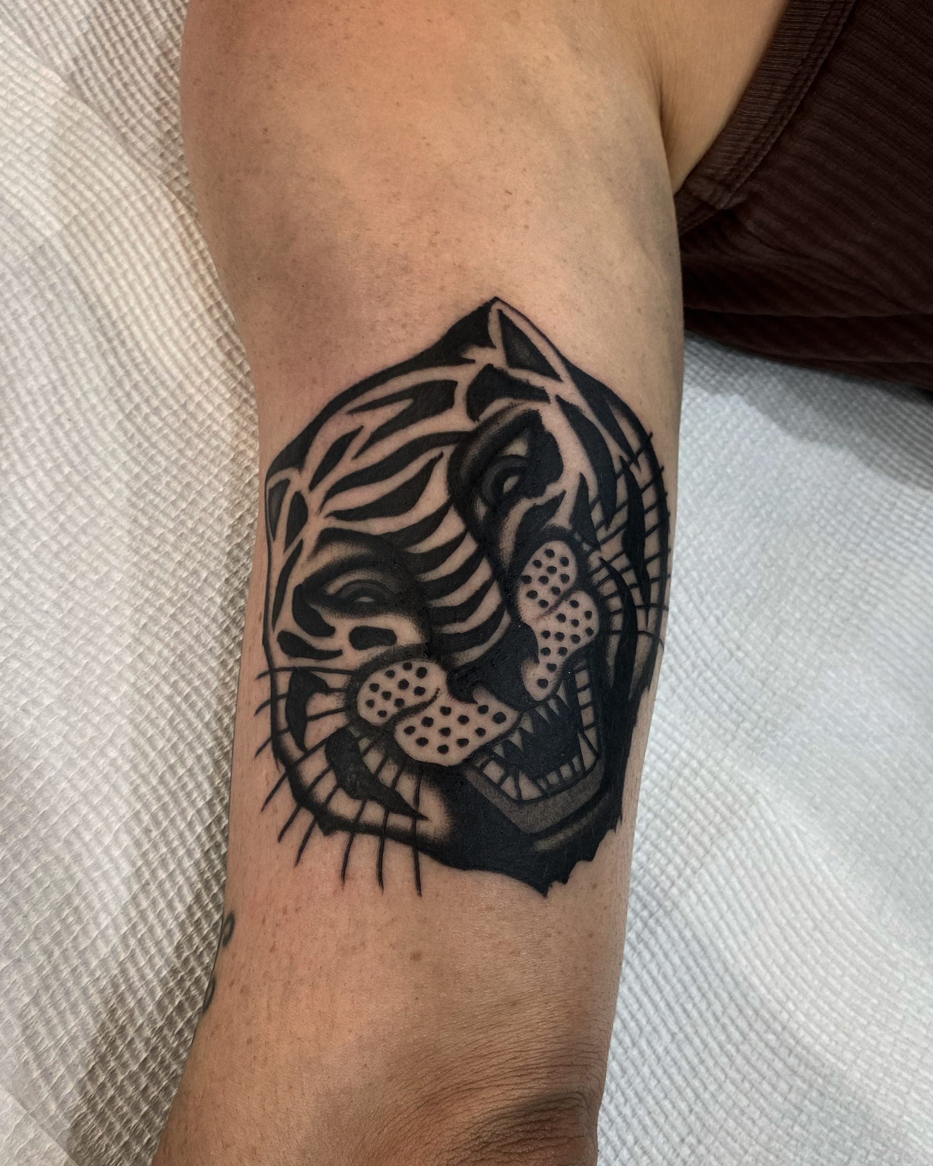 Solid black tiger head with stripes left in negative space on the outer
