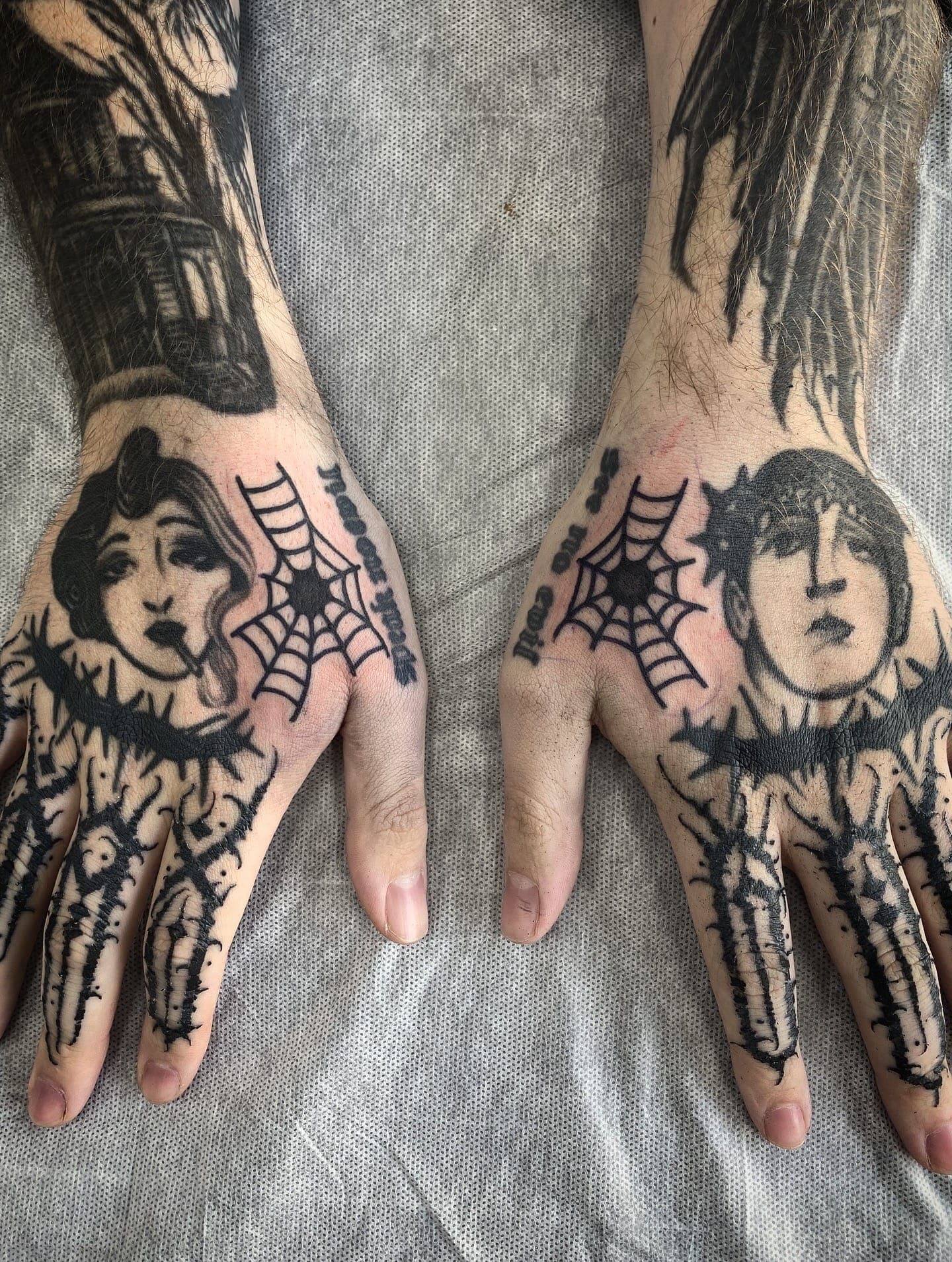 Both tattooed with a jester face, spiderwebs and figural work