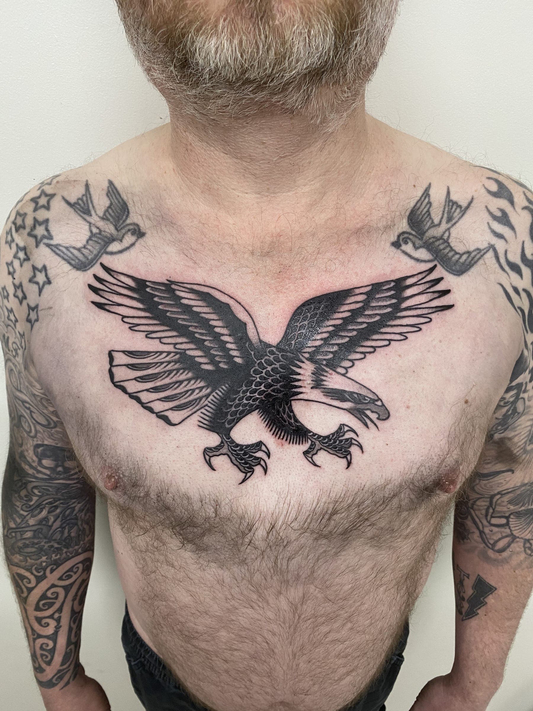Black traditional eagle tattoo with spread wings with stars