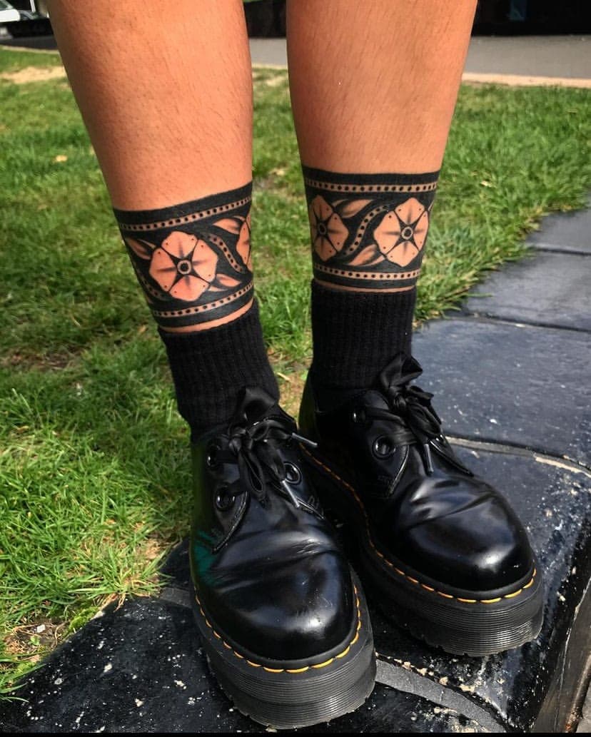 Two matching coral and black flower band tattoos