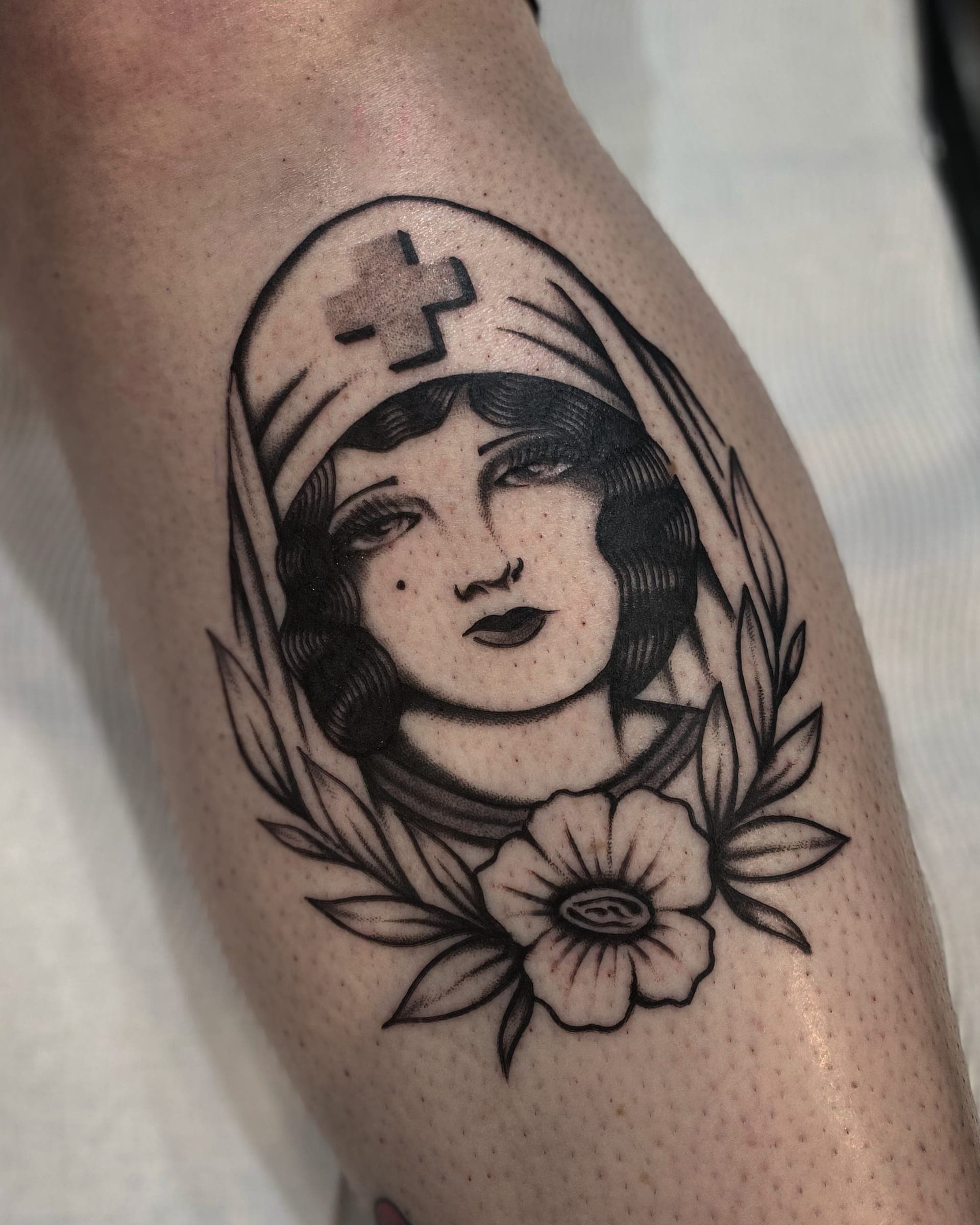 Traditional nurse portrait with red-cross cap and poppy bloom on the back of