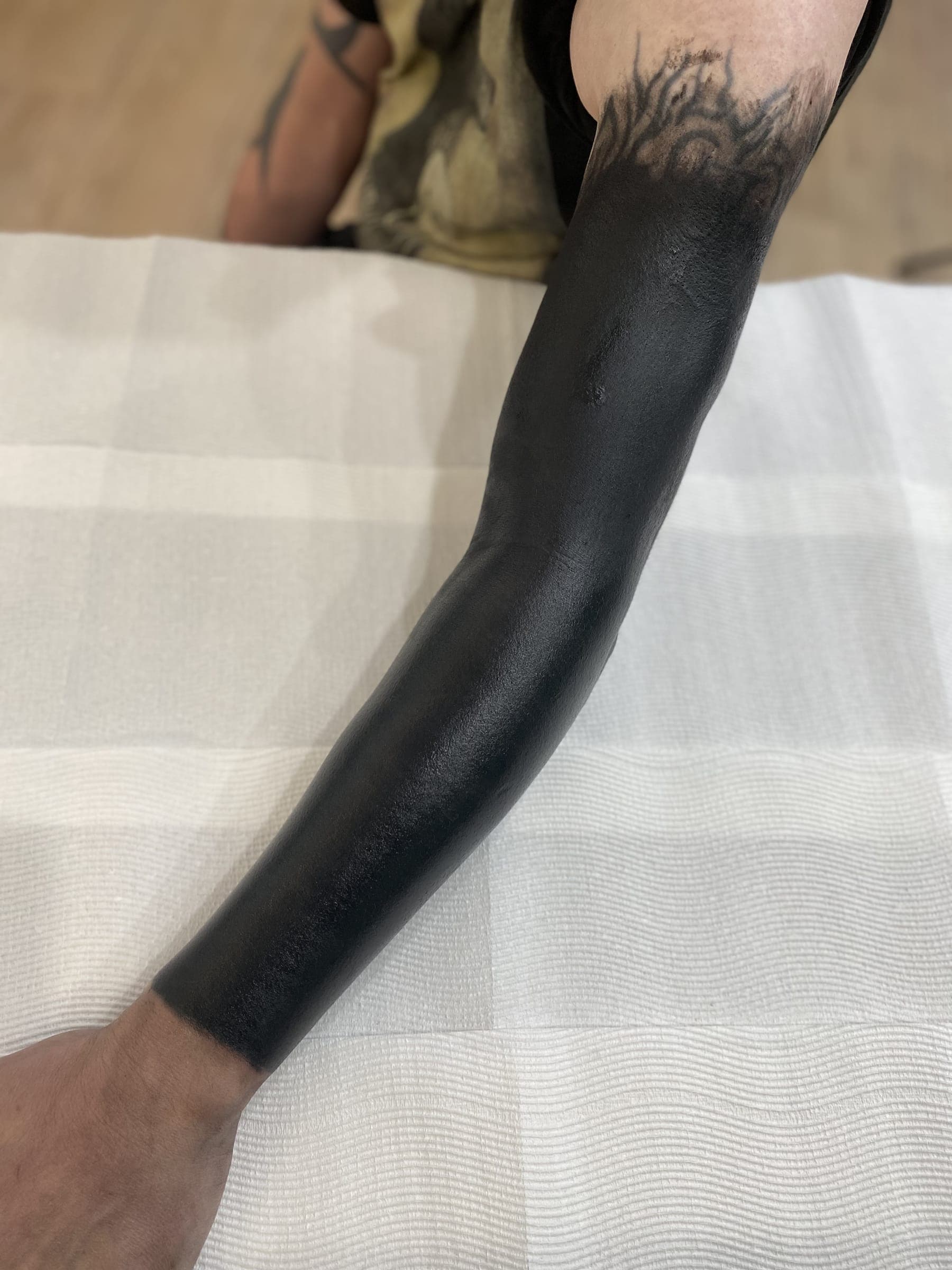 Solid black blackout coverup tattoo over existing work
