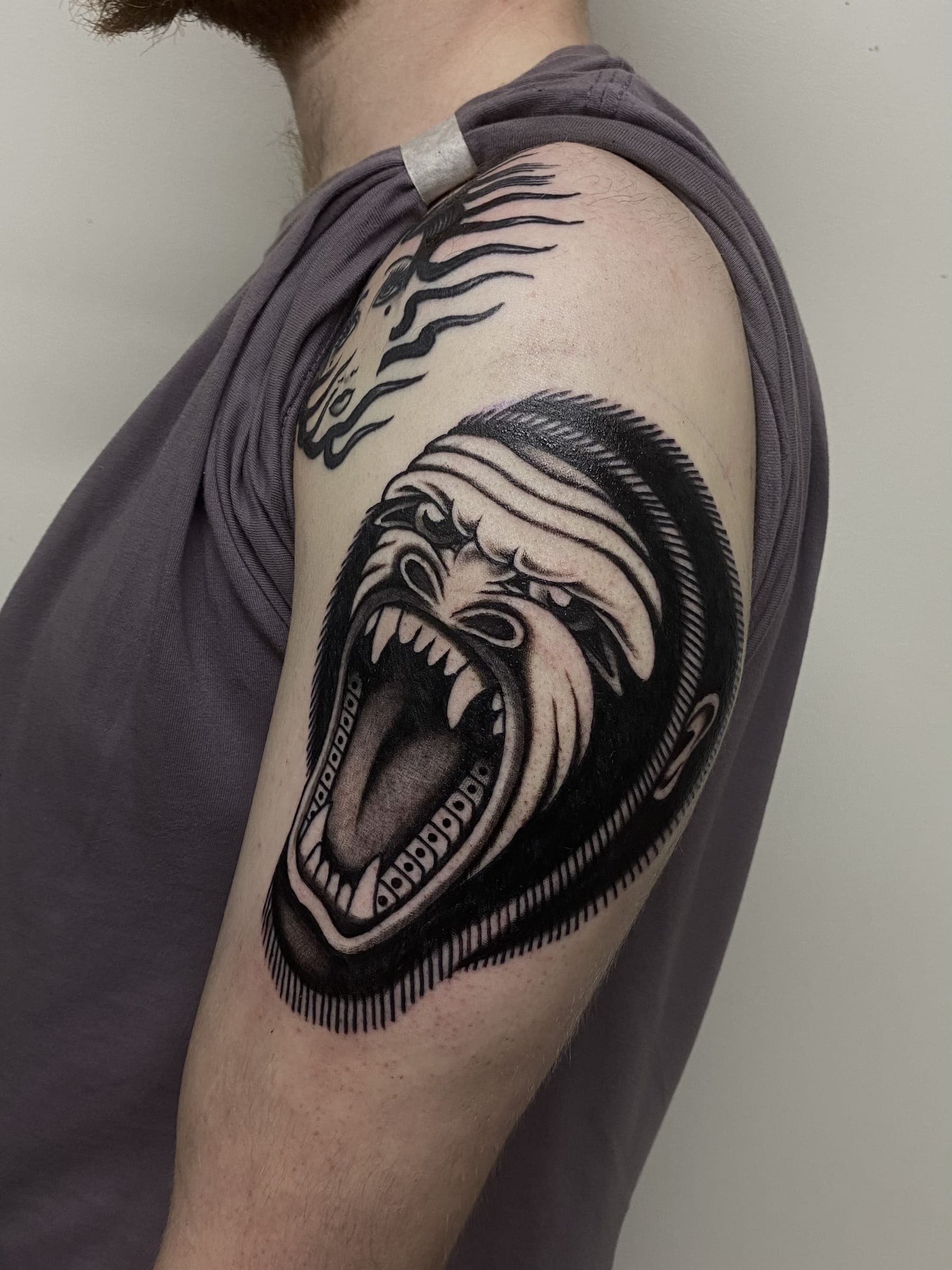 Black screaming gorilla head tattoo with open mouth
