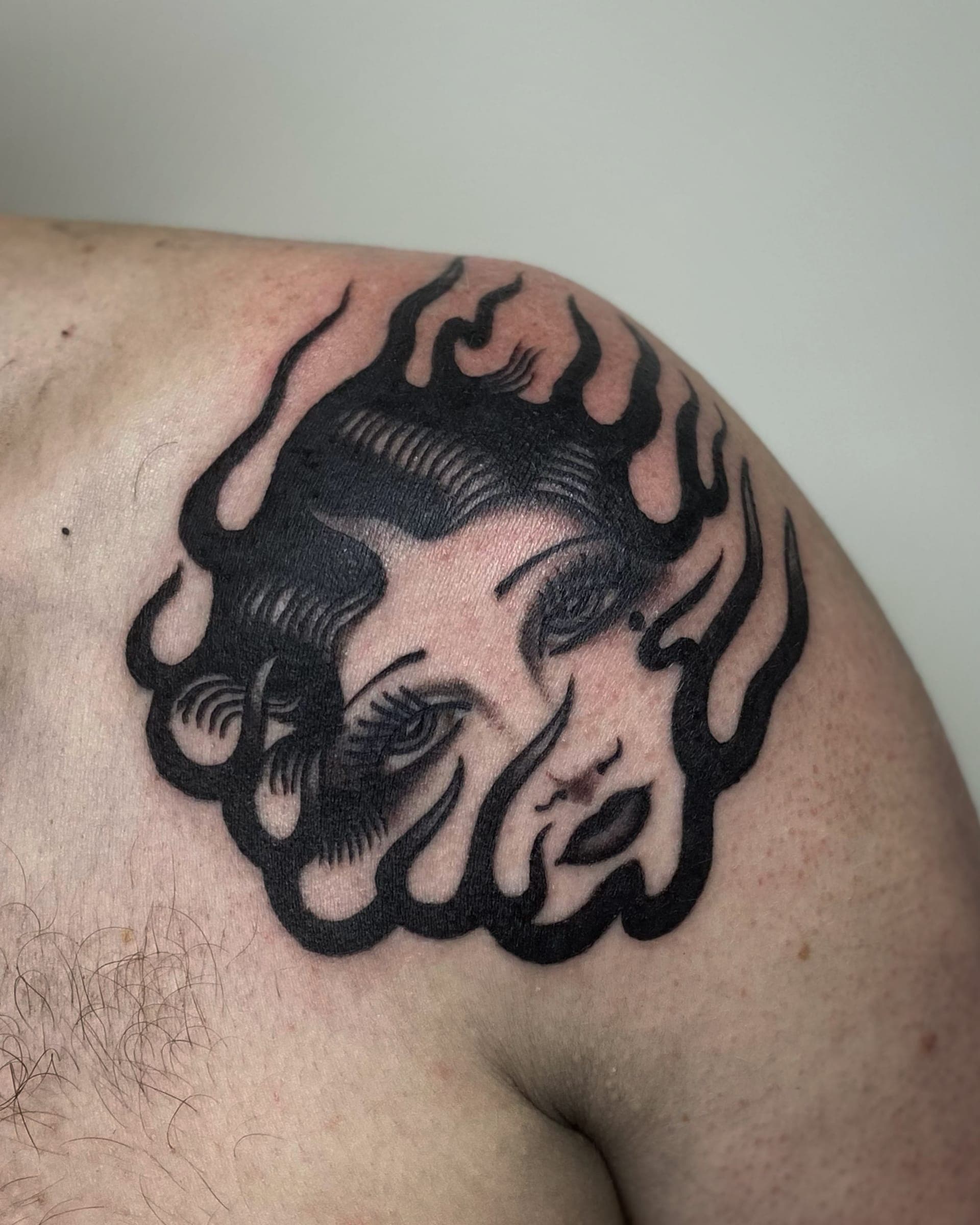 Blackwork woman face surrounded by tongues of solid black flame cap