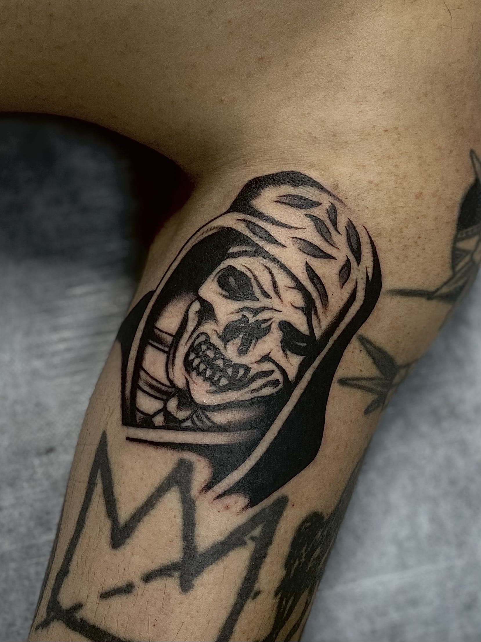 Black traditional grim reaper tattoo laid in a coffin