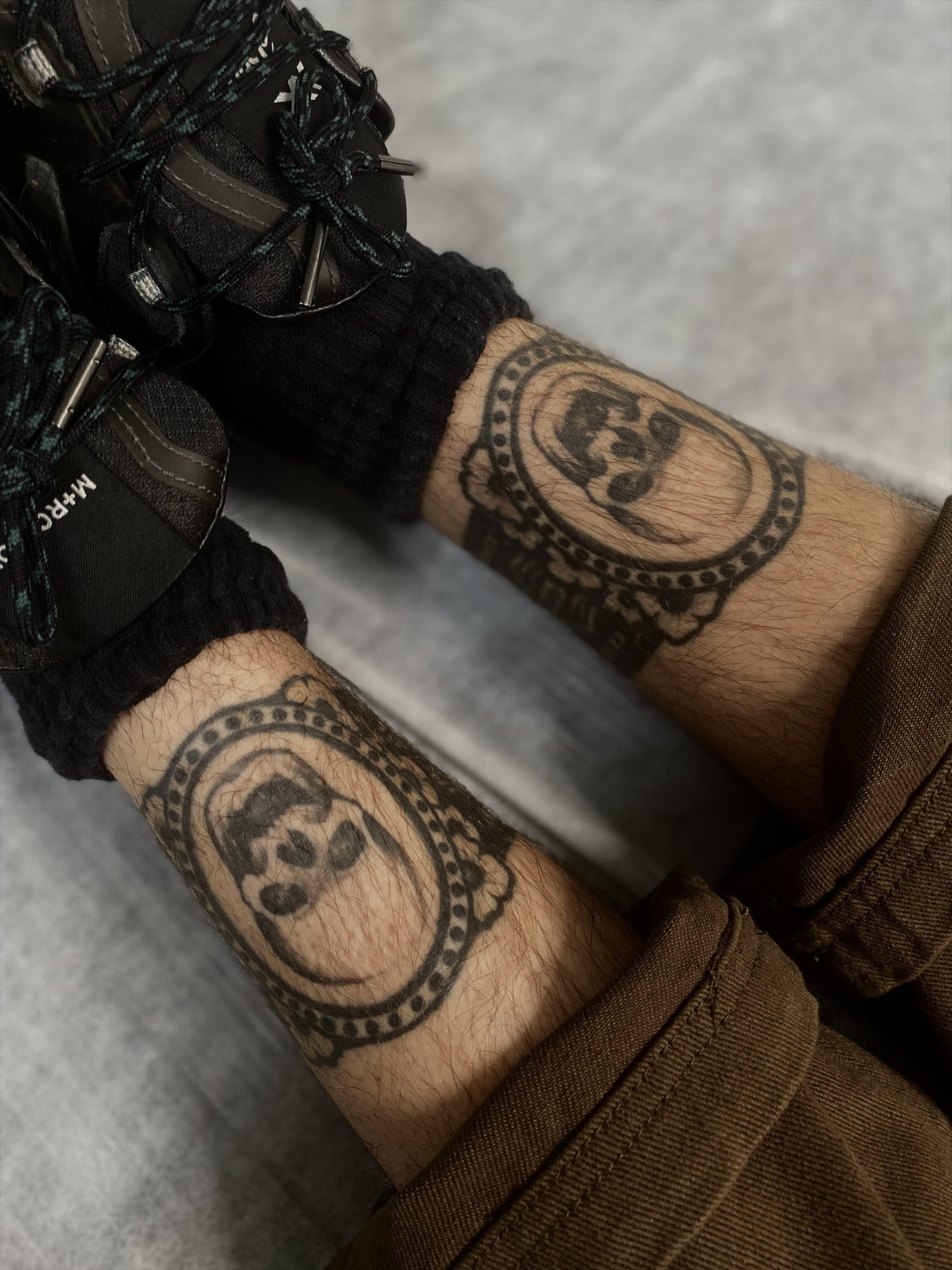 Two matching fine-line panda head cameo tattoos in oval frames