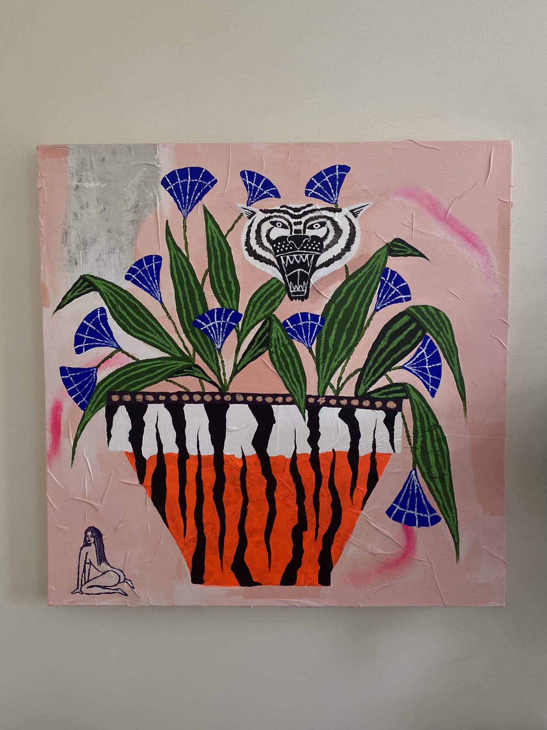 Pink canvas painting of a striped vase with a tiger face and blue flowers