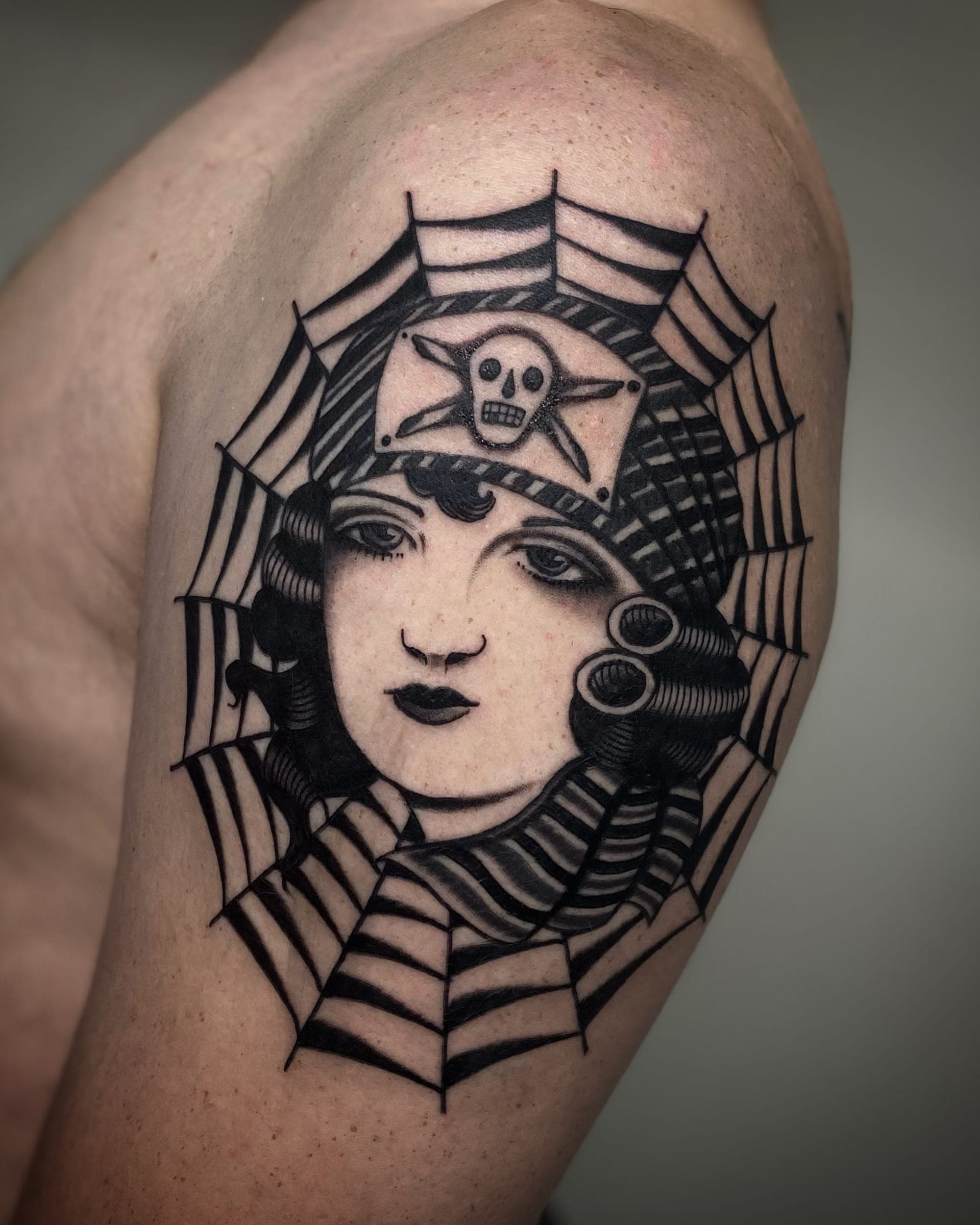 Traditional lady head with waves inside a circular spiderweb with a skull and star badge
